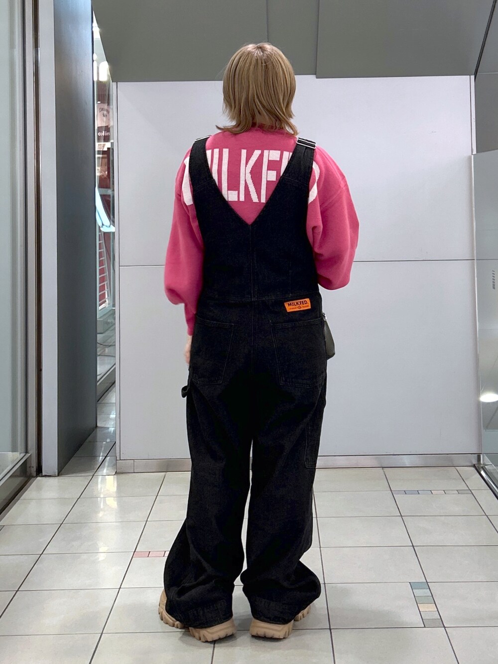 ピンク系のニット/セーター、ブラック系のサロペット/オーバーオール、ブラック系のボストンバッグを着用したレディースの秋コーディネートの3枚目の写真