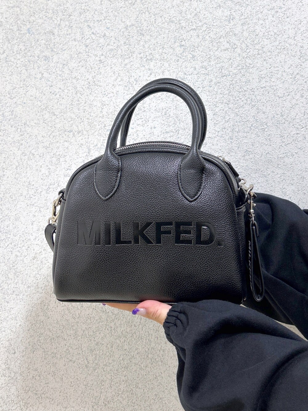 ブラック系のスウェット、ブラック系のボストンバッグ、グリーン系のTシャツ/カットソーを着用したレディースの秋コーディネートの4枚目の写真