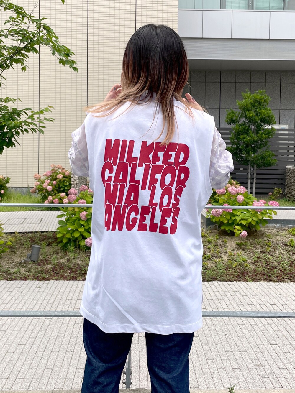 パープル系のシャツ/ブラウス、ホワイト系のTシャツ/カットソー、ブルー系のデニムパンツを着用したレディースの夏コーディネートの3枚目の写真