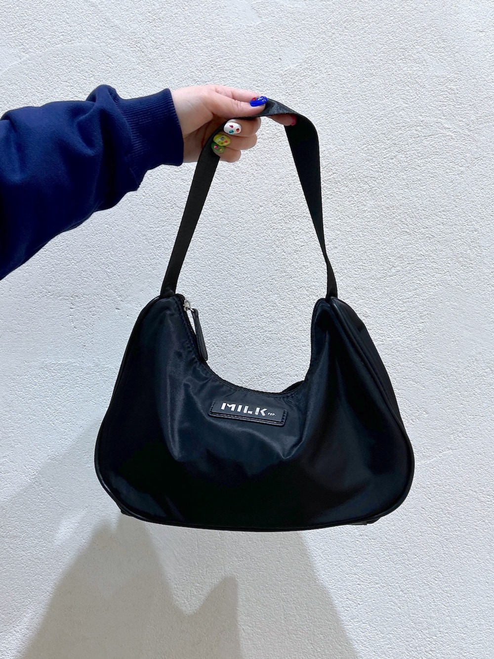 ブルー系のパーカー、イエロー系のその他パンツ、ブラック系のハンドバッグを着用したレディースの冬コーディネートの6枚目の写真