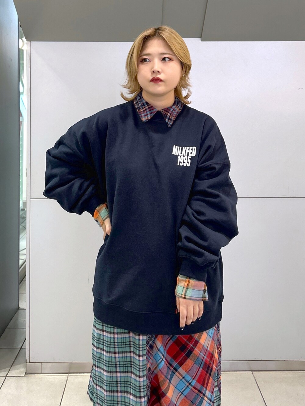 ブルー系のスウェット、ブラウン系のボストンバッグ、グリーン系のシャツワンピースを着用したレディースの秋コーディネートの3枚目の写真