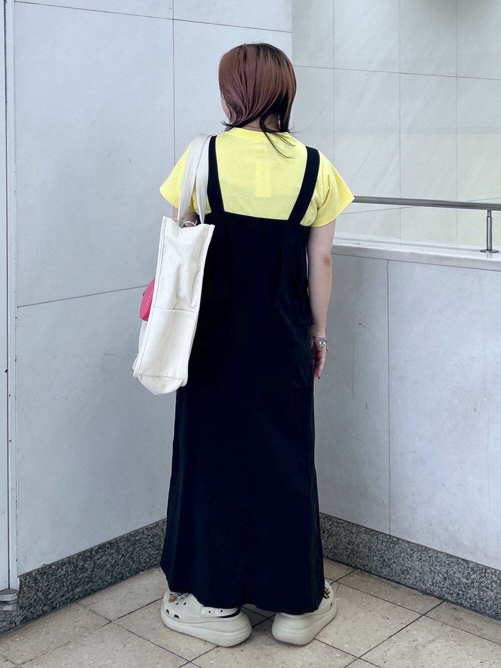イエロー系のTシャツ/カットソー、ブラック系のワンピース、ホワイト系のショルダーバッグを着用したレディースの夏コーディネートの4枚目の写真