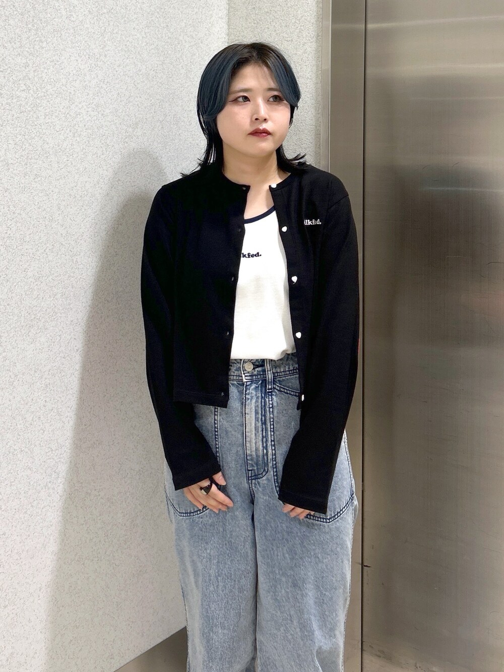 ブルー系のハンドバッグ、ブルー系のデニムパンツ、ベージュ系のサンダルを着用したレディースの夏コーディネートの5枚目の写真