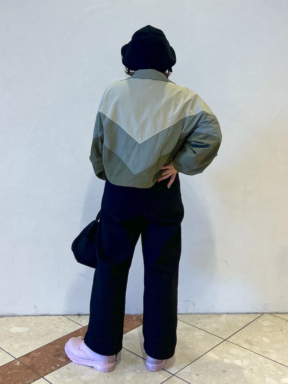 グレー系のTシャツ/カットソー、ベージュ系のナイロンジャケット、ブラック系のサロペット/オーバーオールを着用したレディースの春コーディネートの5枚目の写真