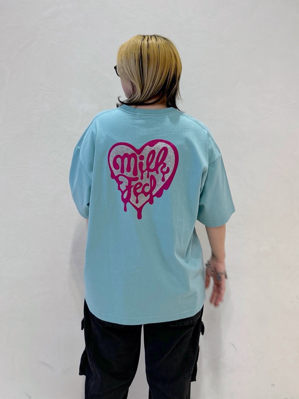 グリーン系のTシャツ/カットソー、ブラック系のカーゴパンツ、ホワイト系のショルダーバッグを着用したレディースの春コーディネートの6枚目の写真