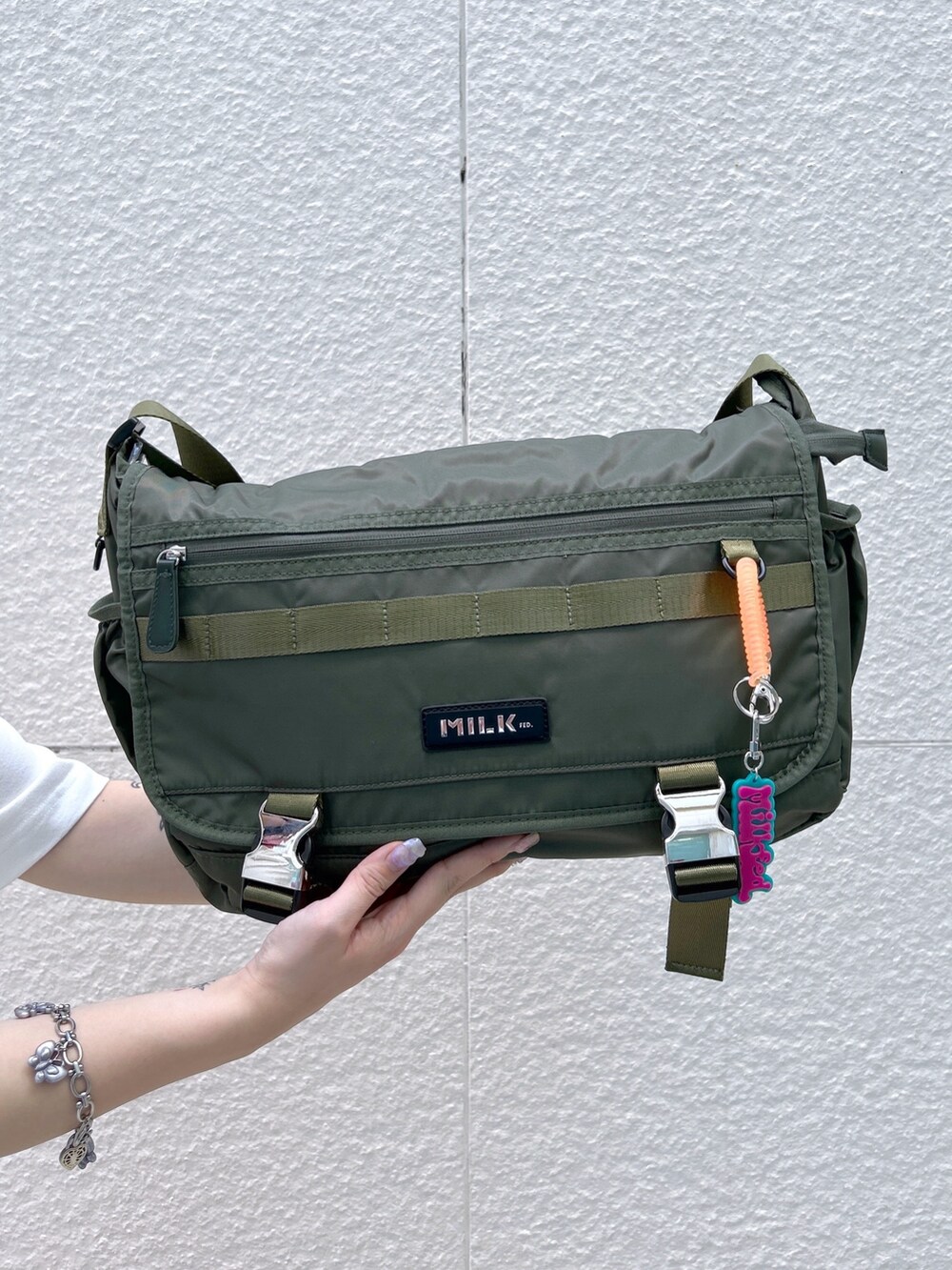 ピンク系のその他パンツ、グリーン系のメッセンジャーバッグ、ホワイト系のTシャツ/カットソーを着用したレディースの春コーディネートの6枚目の写真