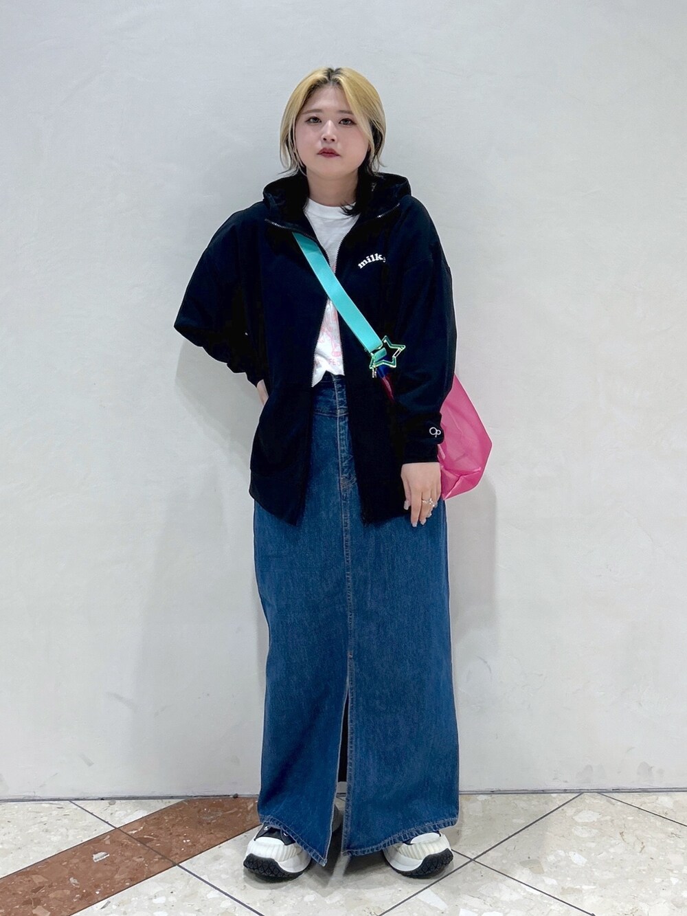 ブルー系のデニムスカート、ピンク系のショルダーバッグ、ホワイト系のTシャツ/カットソーを着用したレディースの春コーディネートの2枚目の写真