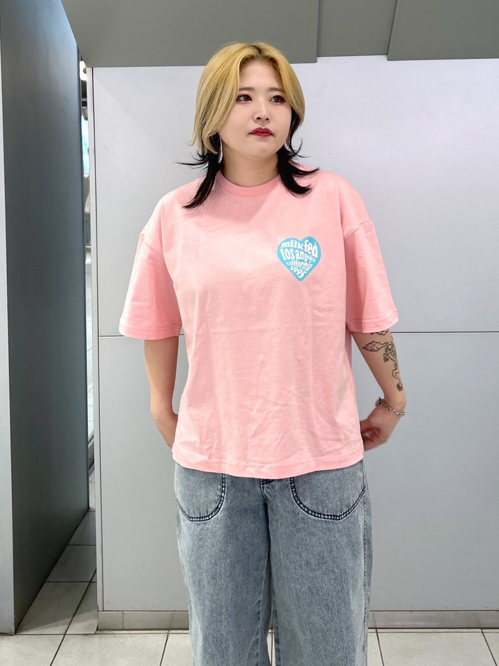 ピンク系のTシャツ/カットソー、ブルー系のデニムパンツ、ブラック系のショルダーバッグを着用したレディースの春コーディネートの5枚目の写真