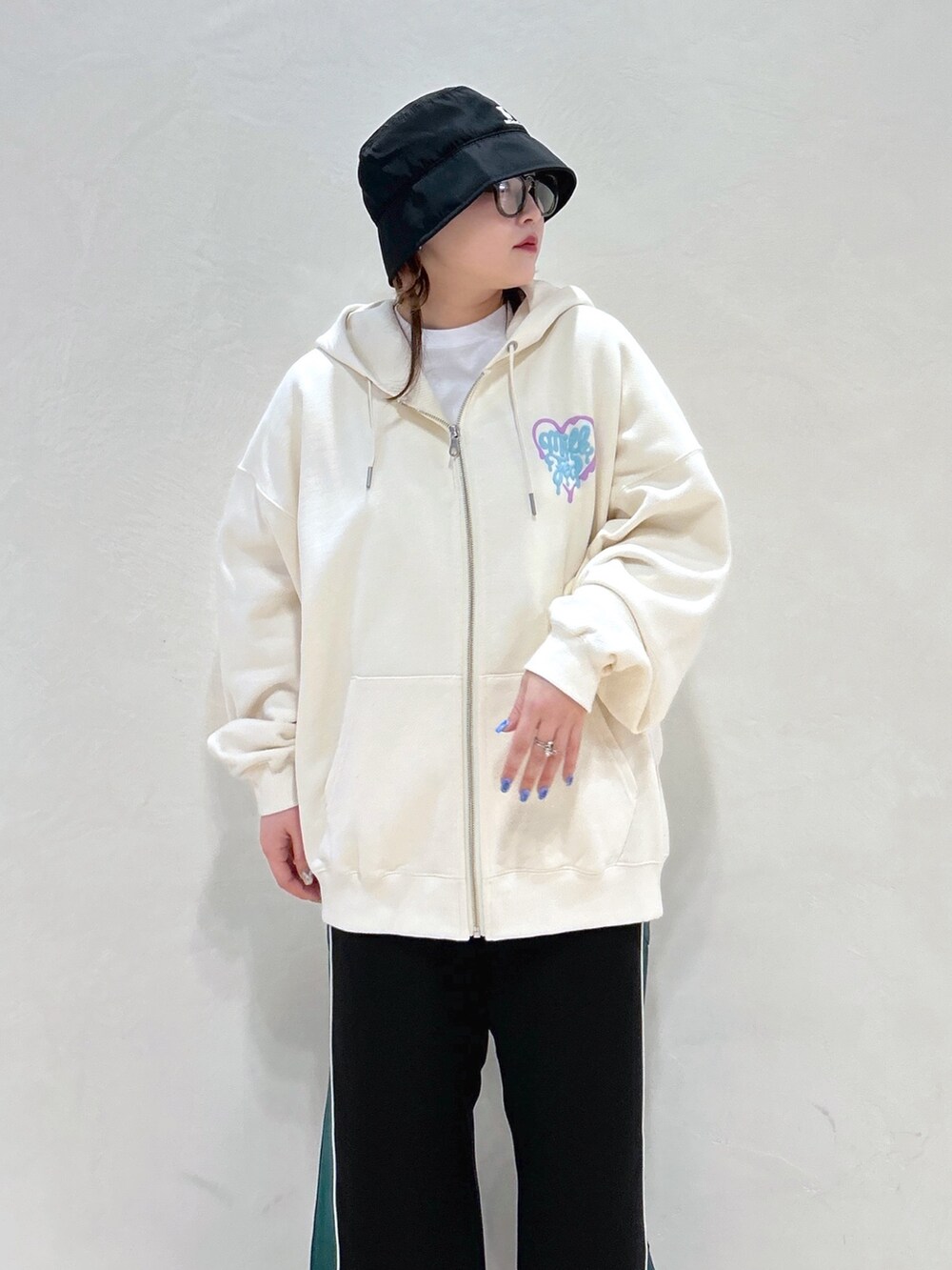 ホワイト系のパーカー、ブラック系のその他パンツ、グリーン系のトートバッグを着用したレディースの春コーディネートの4枚目の写真