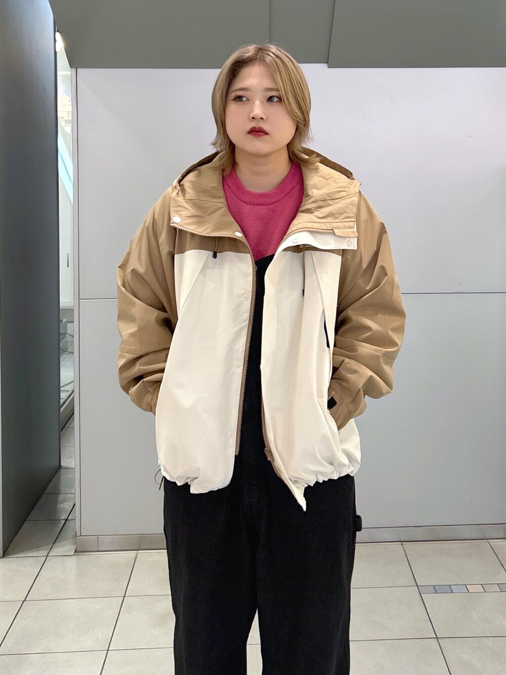 ベージュ系のマウンテンパーカー、ピンク系のニット/セーター、ブラック系のサロペット/オーバーオールを着用したレディースの秋コーディネートの3枚目の写真