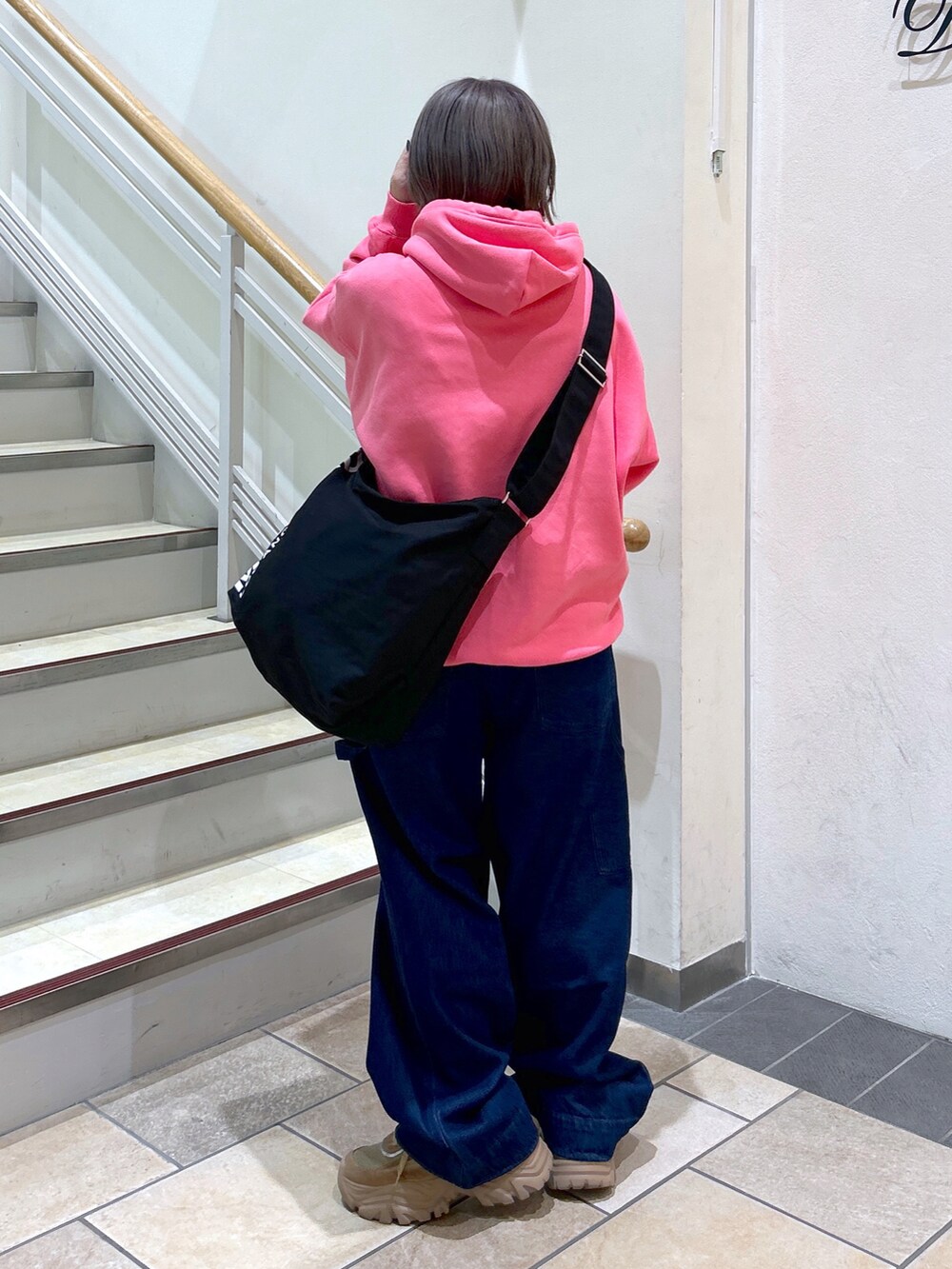 ピンク系のパーカー、ブラック系のショルダーバッグ、ブルー系のサロペット/オーバーオールを着用したレディースの秋コーディネートの2枚目の写真