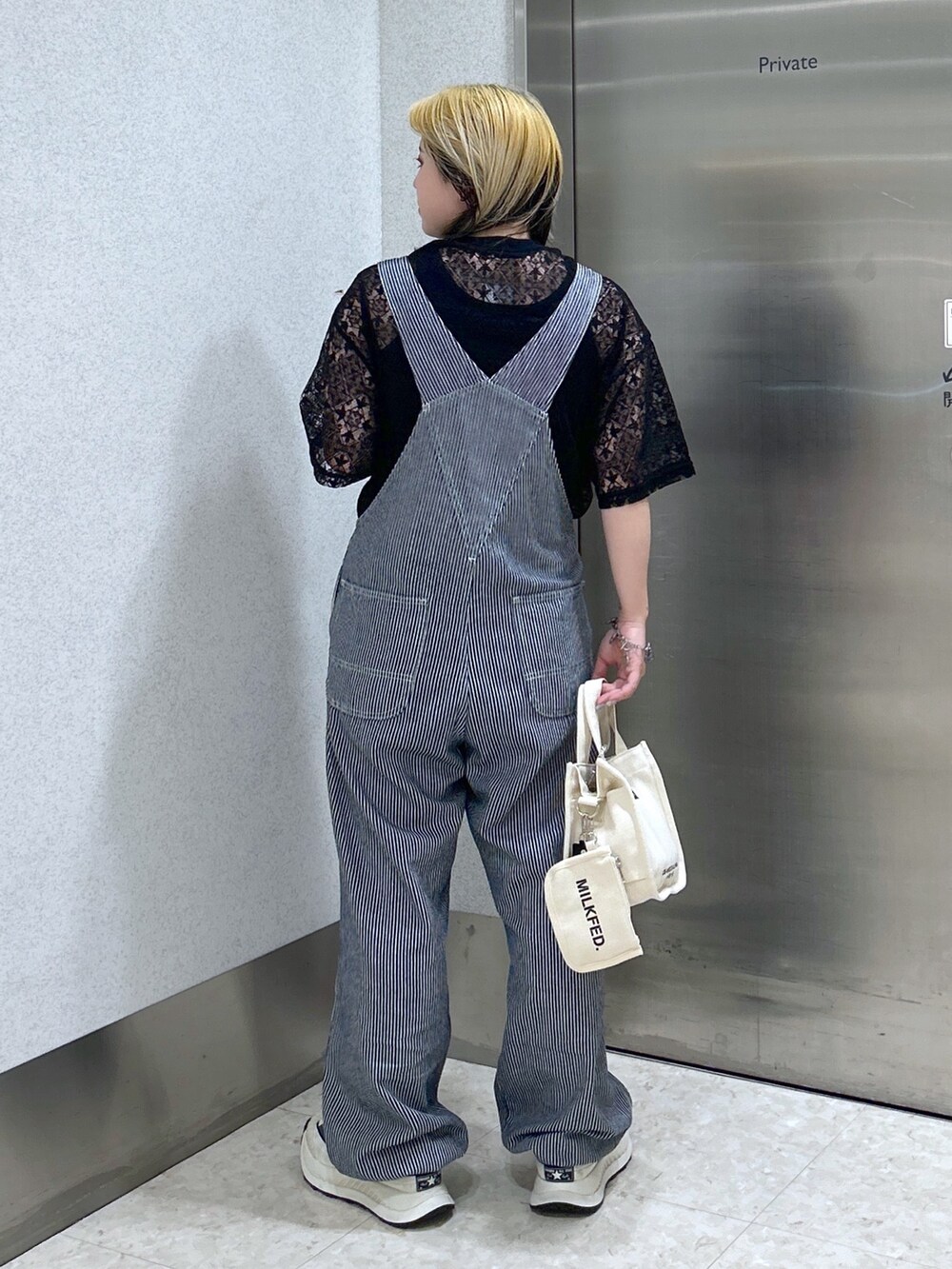 ホワイト系のショルダーバッグ、ブラック系のタンクトップ、ブラック系のTシャツ/カットソーを着用したレディースの春コーディネートの3枚目の写真