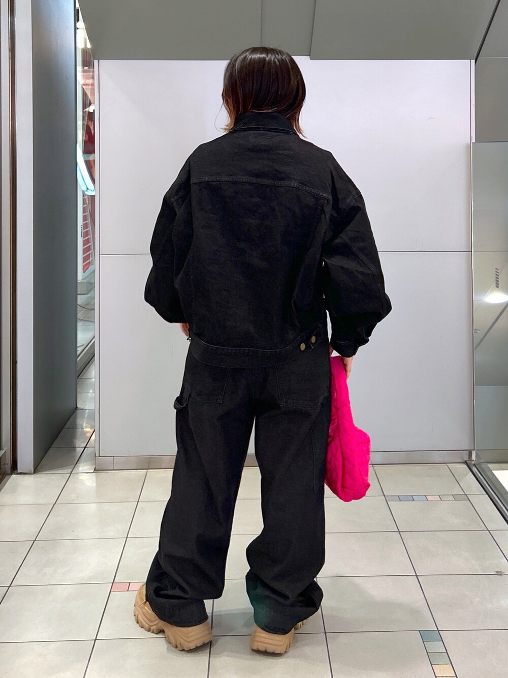 ブラック系のデニムジャケット、ブラック系のサロペット/オーバーオール、ピンク系のハンドバッグを着用したレディースの秋コーディネートの3枚目の写真