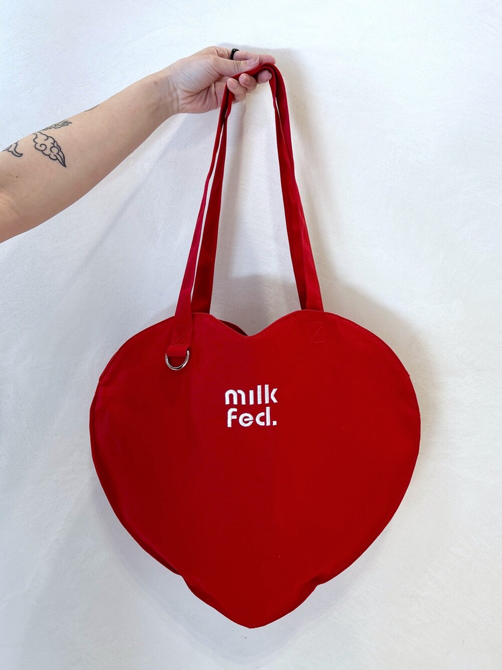 ブラック系のTシャツ/カットソー、ブルー系のデニムスカート、レッド系のトートバッグを着用したレディースの夏コーディネートの7枚目の写真