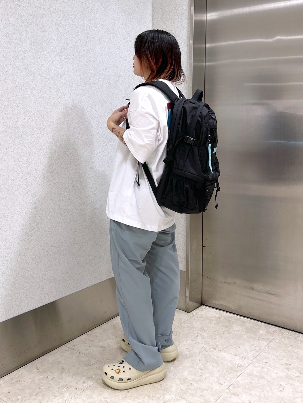 ホワイト系のTシャツ/カットソー、ブルー系のその他パンツ、ブラック系のバックパック/リュックを着用したレディースの夏コーディネートの4枚目の写真