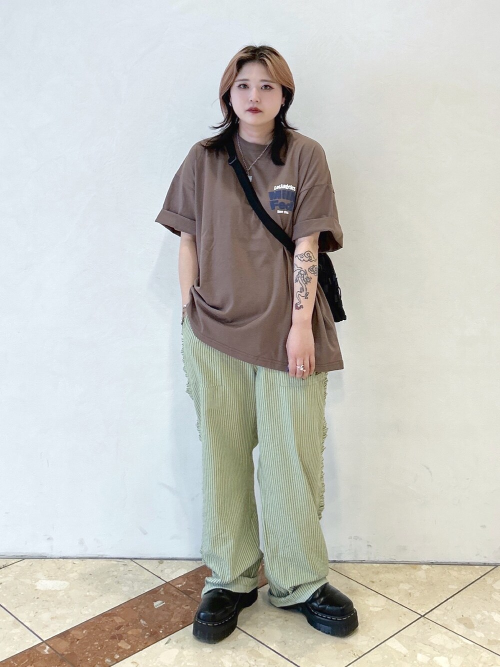 ブラウン系のTシャツ/カットソー、グリーン系のその他パンツ、ピンク系のショルダーバッグを着用したレディースの夏コーディネートの2枚目の写真