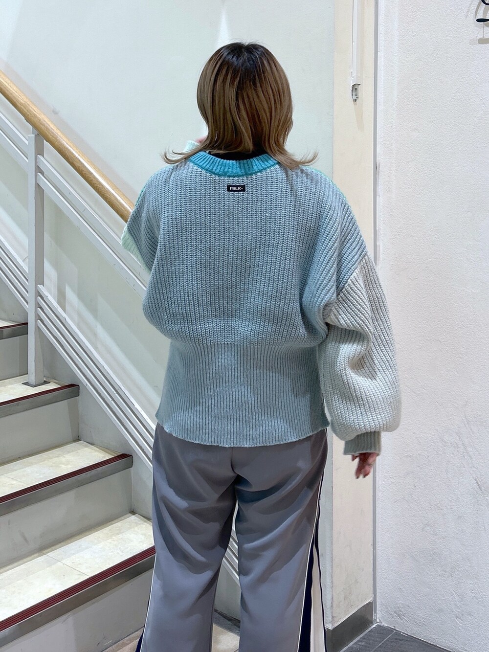 グリーン系のニット/セーター、ブラック系のショルダーバッグ、ブラック系のブーツを着用したレディースの冬コーディネートの6枚目の写真