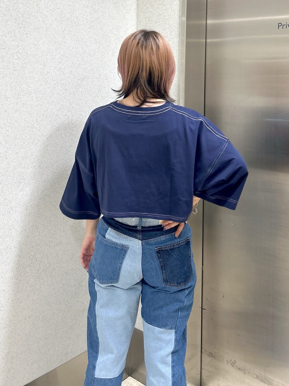 ブルー系のデニムパンツ、ブルー系のTシャツ/カットソー、ベージュ系のサンダルを着用したレディースの夏コーディネートの4枚目の写真