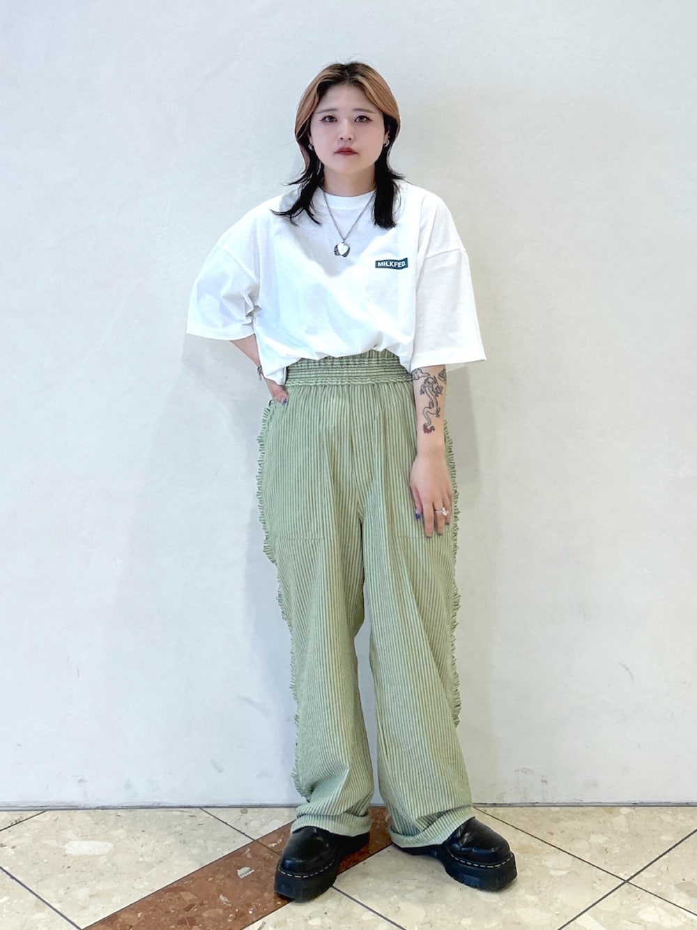 ホワイト系のTシャツ/カットソー、ブラック系のトートバッグ、グリーン系のその他パンツを着用したレディースの夏コーディネートの4枚目の写真