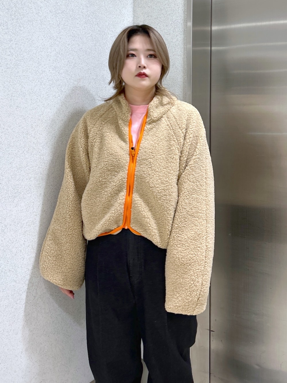 ピンク系のボディバッグ/ウエストポーチ、ピンク系のTシャツ/カットソー、ベージュ系のブルゾンを着用したレディースの冬コーディネートの3枚目の写真