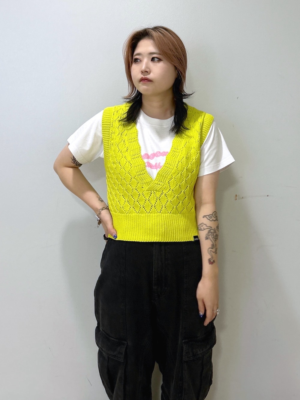 ホワイト系のTシャツ/カットソー、イエロー系のベスト、ブラック系のカーゴパンツを着用したレディースの夏コーディネートの5枚目の写真