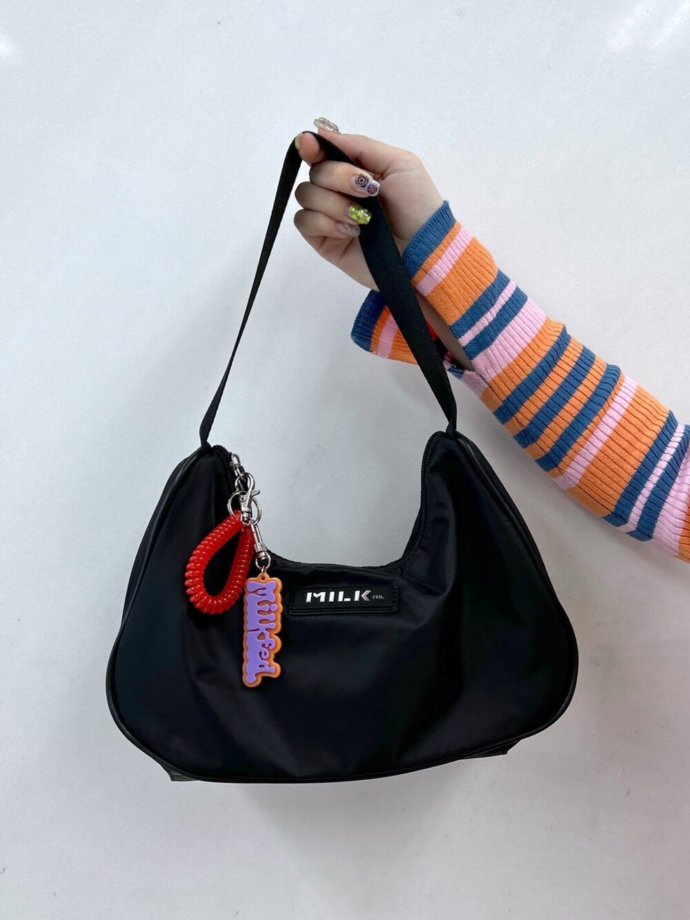 オレンジ系のカーディガン/ボレロ、ピンク系のその他パンツ、ブラック系のハンドバッグを着用したレディースの春コーディネートの8枚目の写真