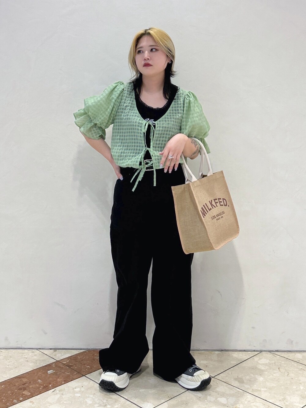 ブラック系のタンクトップ、グリーン系のシャツ/ブラウス、ブラック系のデニムパンツを着用したレディースの春コーディネートの2枚目の写真