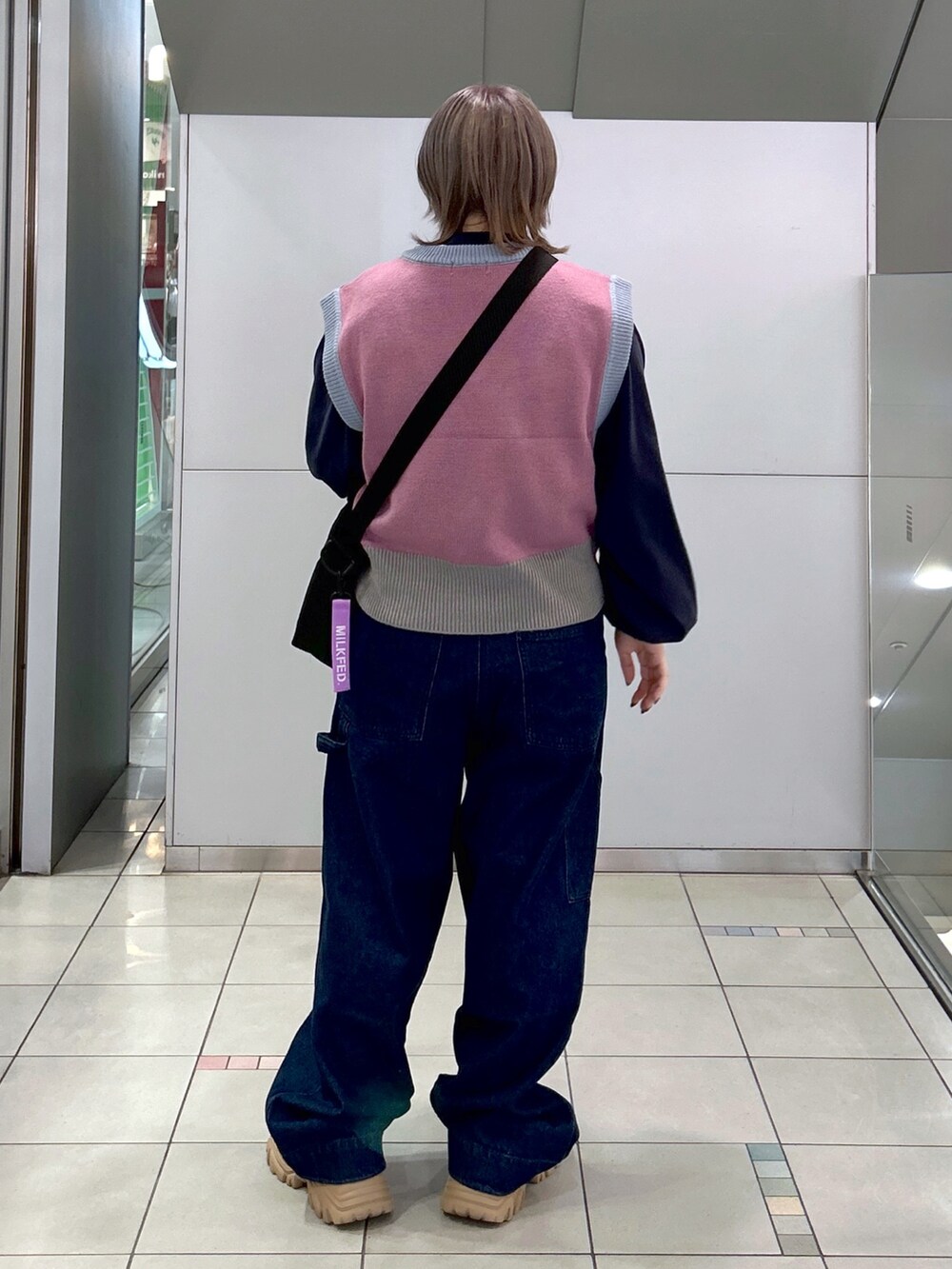 パープル系のベスト、ホワイト系のTシャツ/カットソー、パープル系のショルダーバッグを着用したレディースの秋コーディネートの3枚目の写真