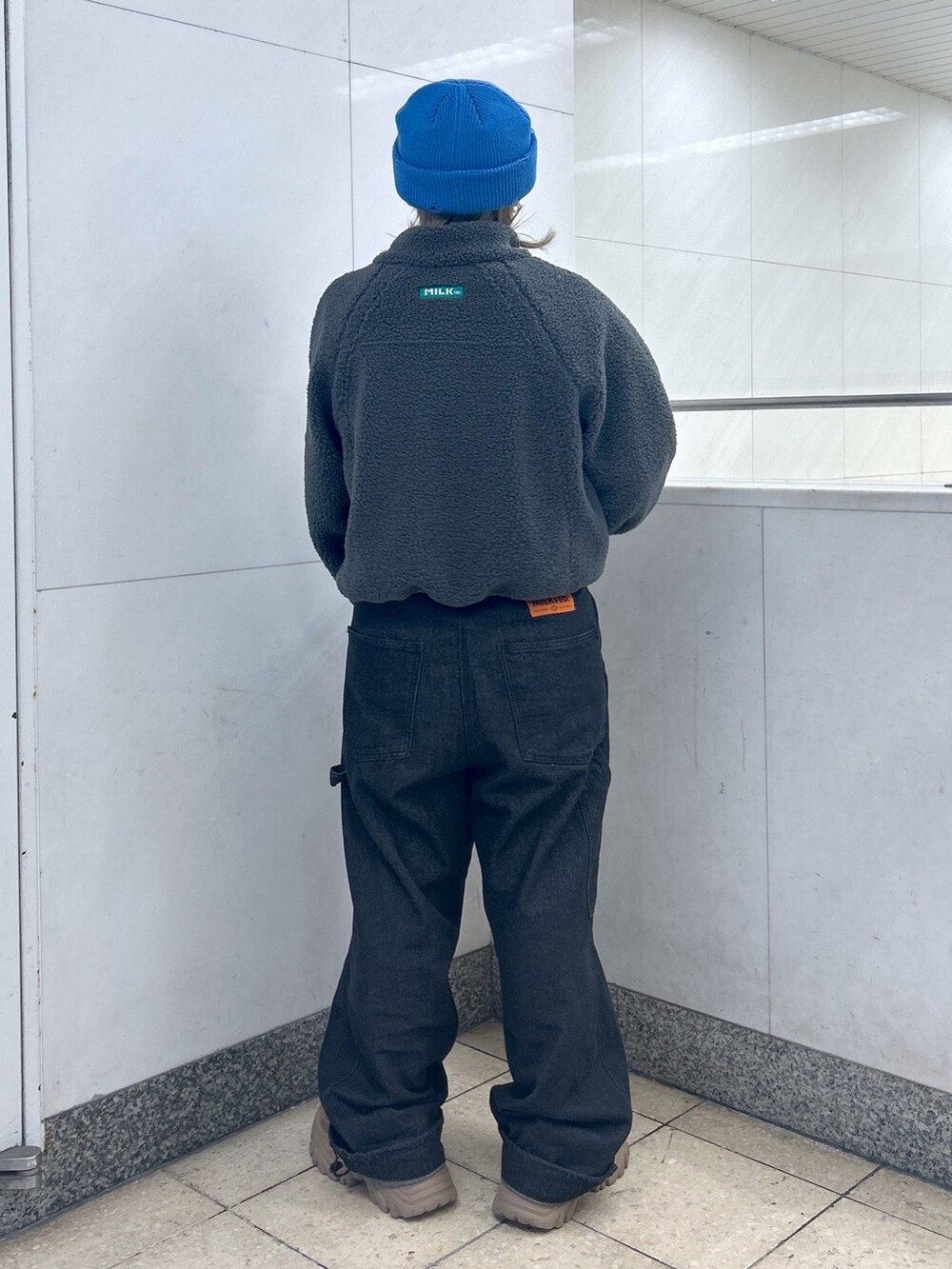 グレー系のブルゾン、ブルー系のTシャツ/カットソー、ブラック系のサロペット/オーバーオールを着用したレディースの秋コーディネートの2枚目の写真