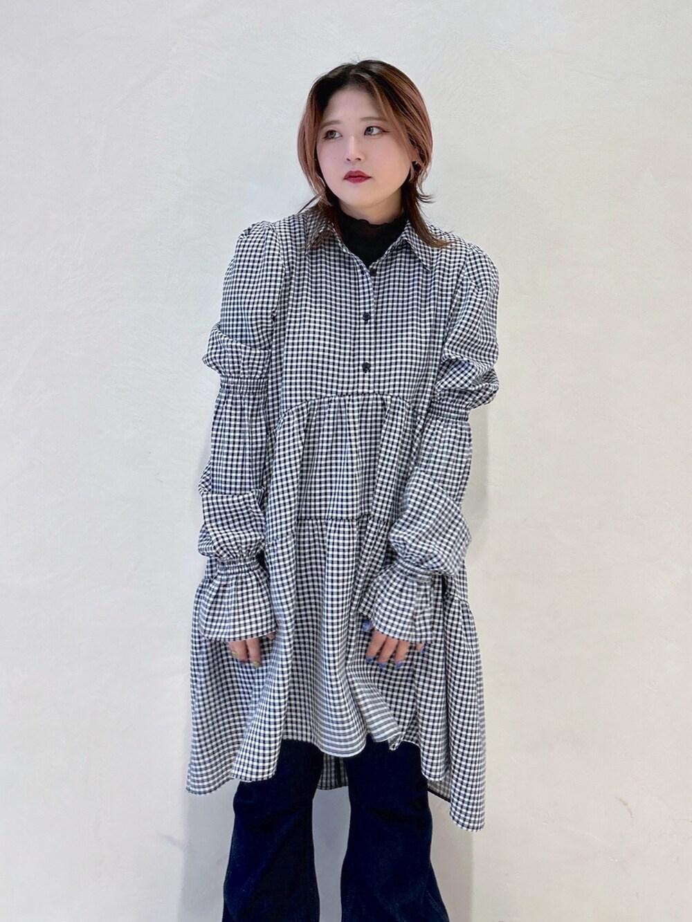 ブラック系のワンピース、ブルー系のデニムパンツ、ブラウン系のショルダーバッグを着用したレディースの春コーディネートの5枚目の写真