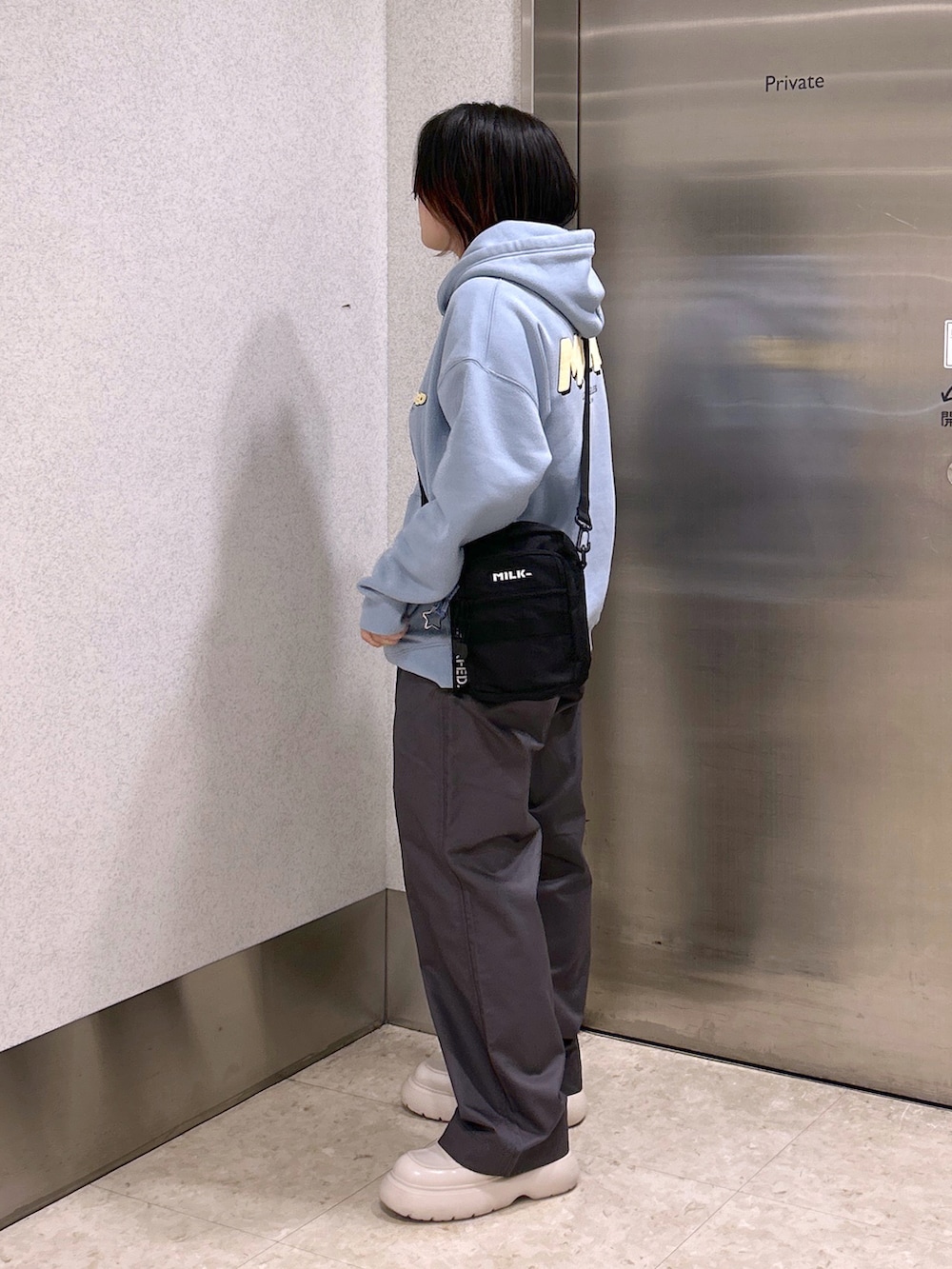 ブルー系のパーカー、ブラック系のショルダーバッグ、グレー系のその他パンツを着用したレディースの夏コーディネートの2枚目の写真