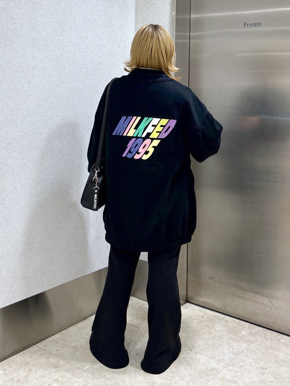 ブラック系のスウェット、ブラック系のボストンバッグ、グリーン系のTシャツ/カットソーを着用したレディースの秋コーディネートの3枚目の写真