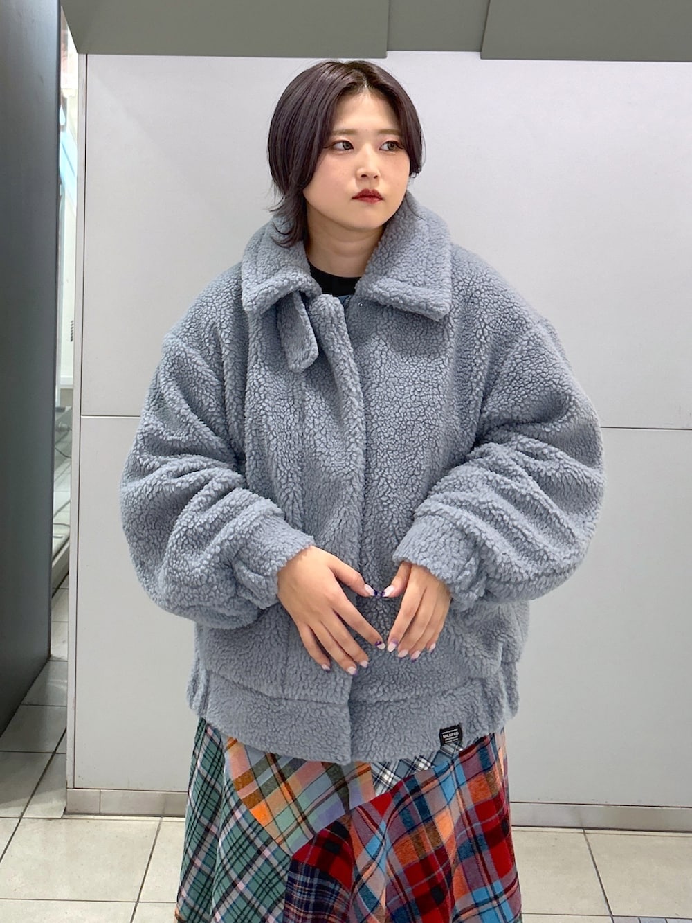 ブラック系のボストンバッグ、グリーン系のスカート、ベージュ系のスニーカーを着用したレディースの秋コーディネートの4枚目の写真