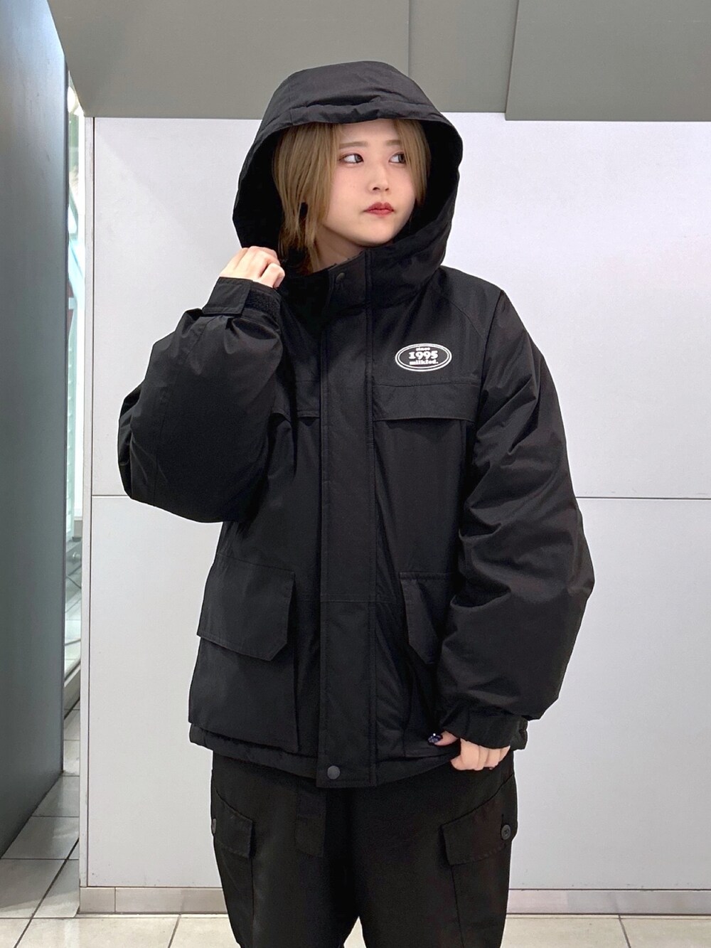 ブラウン系のTシャツ/カットソー、ブラック系のダウンジャケット/コート、ベージュ系のスニーカーを着用したレディースの冬コーディネートの3枚目の写真