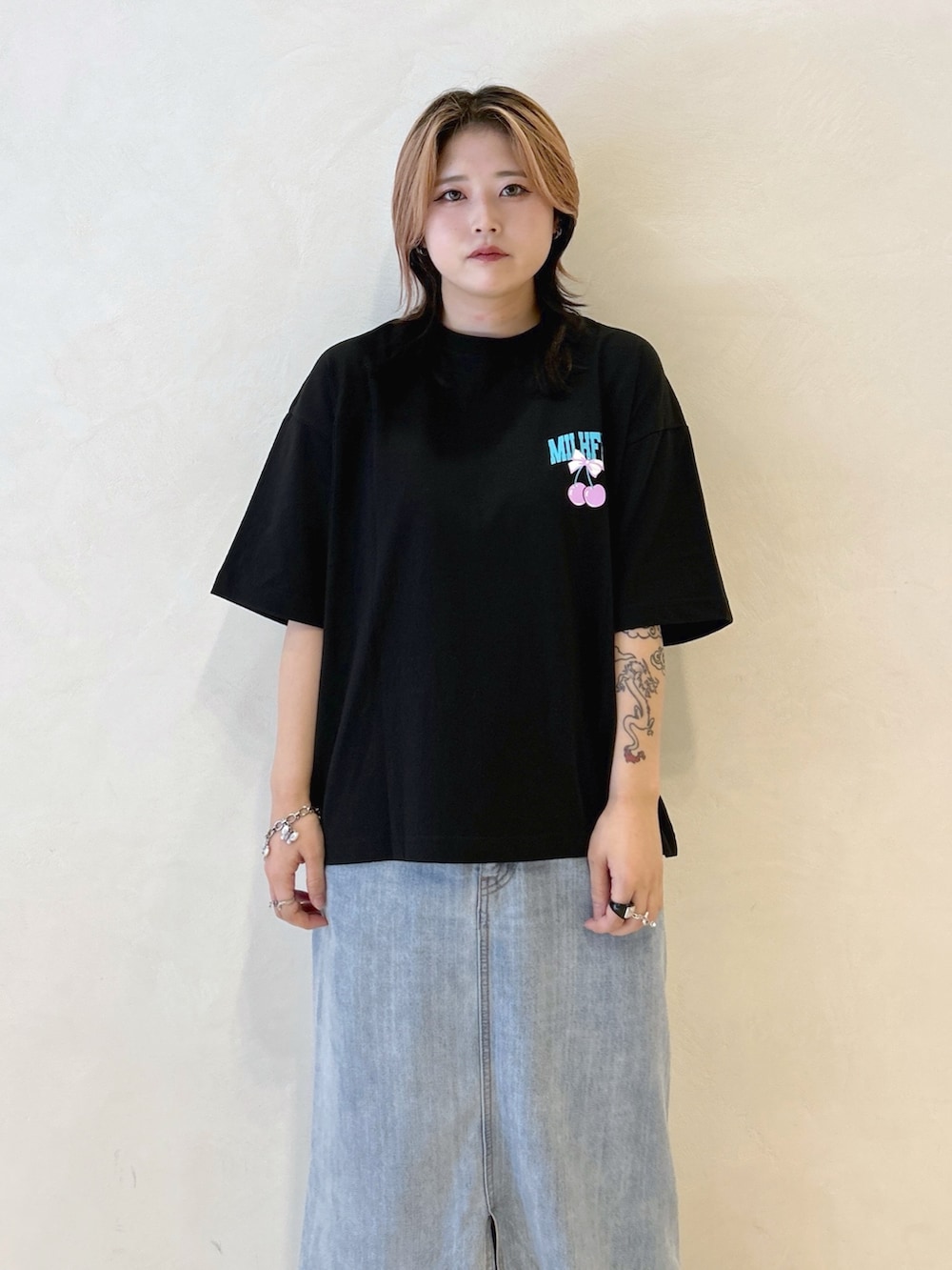 ブラック系のTシャツ/カットソー、ブルー系のデニムスカート、レッド系のトートバッグを着用したレディースの夏コーディネートの5枚目の写真