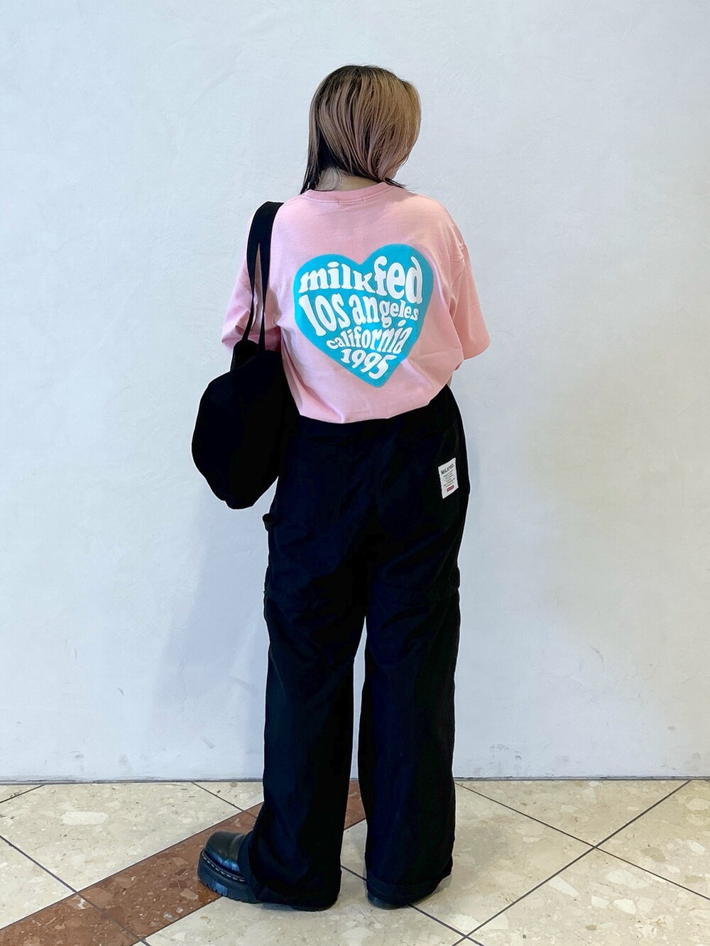 ピンク系のTシャツ/カットソー、ブラック系のその他パンツ、ブラック系のトートバッグを着用したレディースの夏コーディネートの5枚目の写真