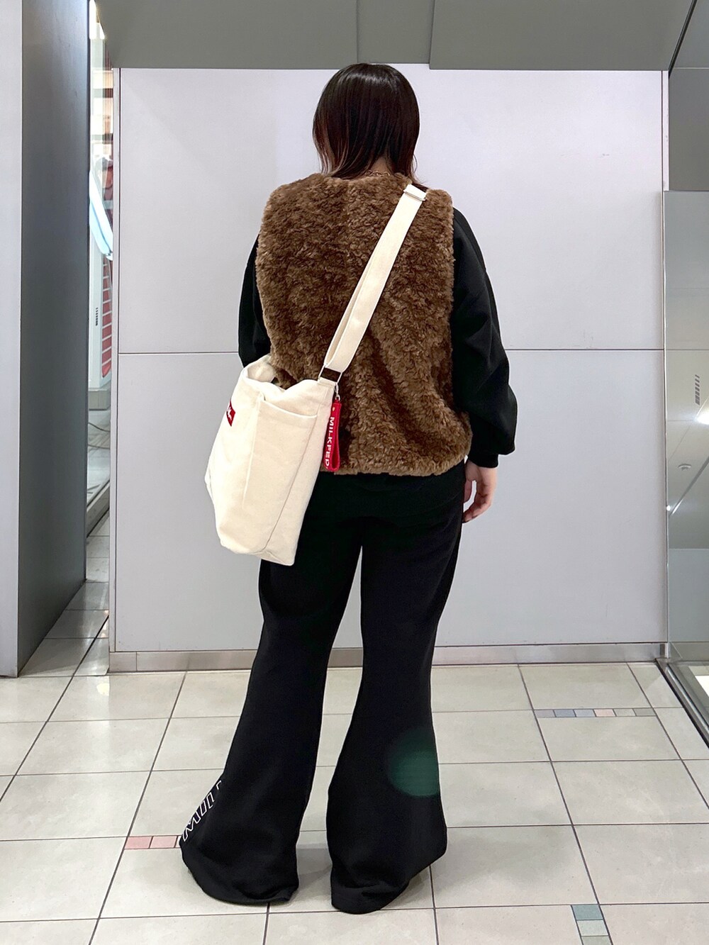 ブラウン系のベスト、ブラック系のTシャツ/カットソー、その他のトートバッグを着用したレディースの秋コーディネートの3枚目の写真