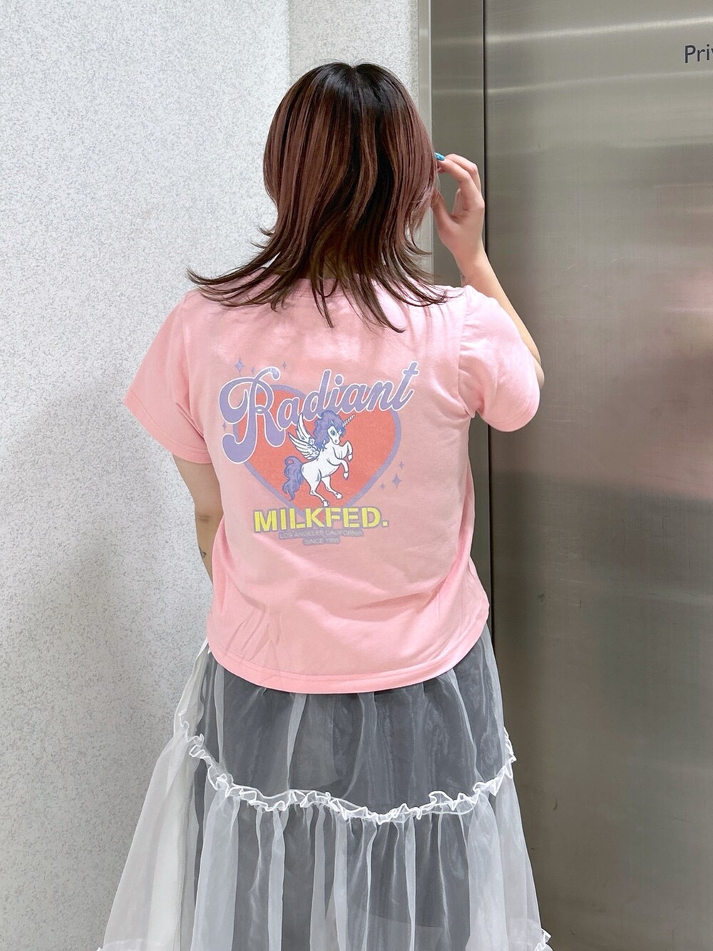 ホワイト系のスカート、ブラック系のデニムパンツ、ブラック系のブーツを着用したレディースの春コーディネートの8枚目の写真