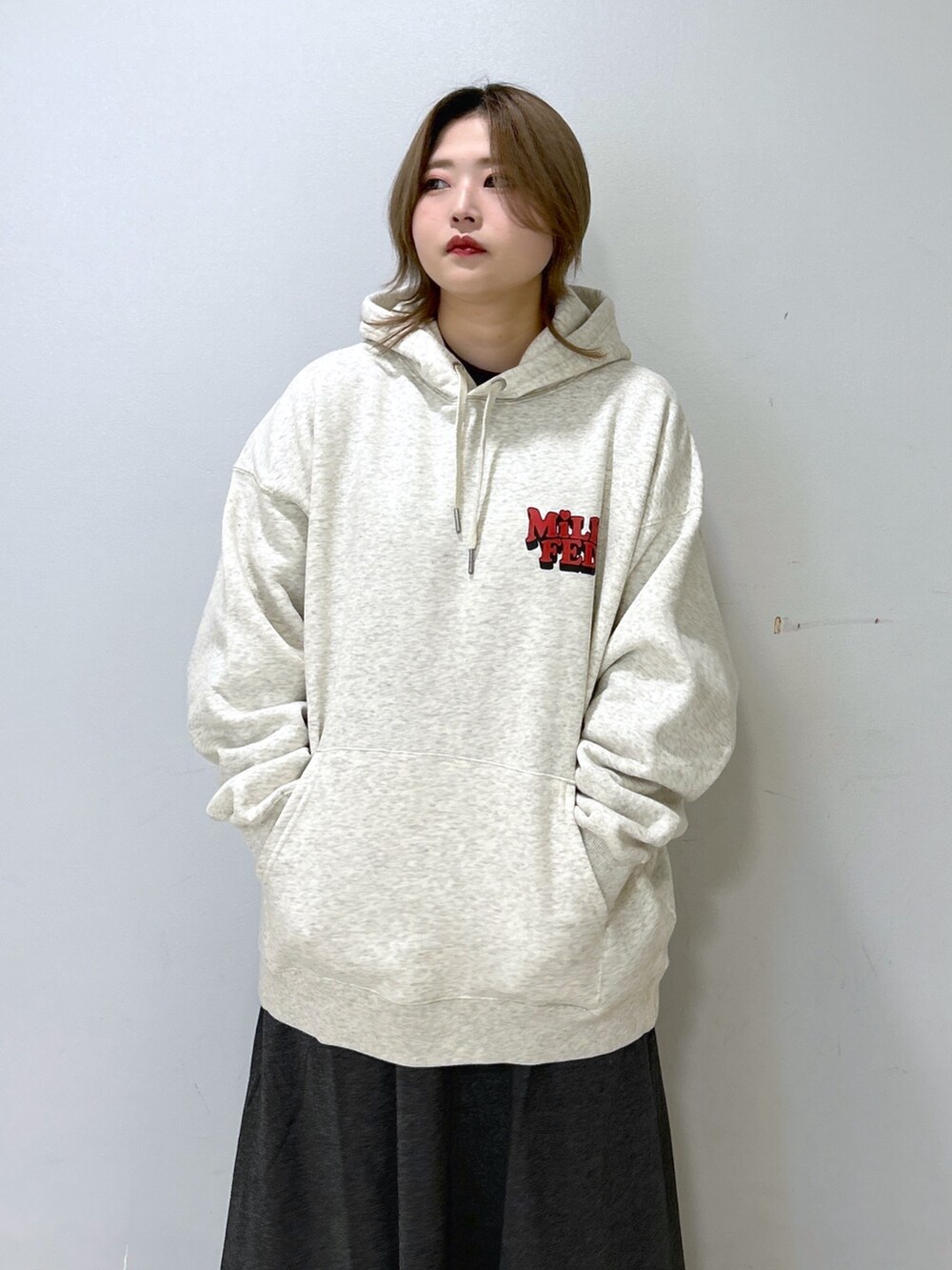 ブルー系のショルダーバッグ、ベージュ系のパーカー、グレー系のワンピースを着用したレディースの冬コーディネートの4枚目の写真