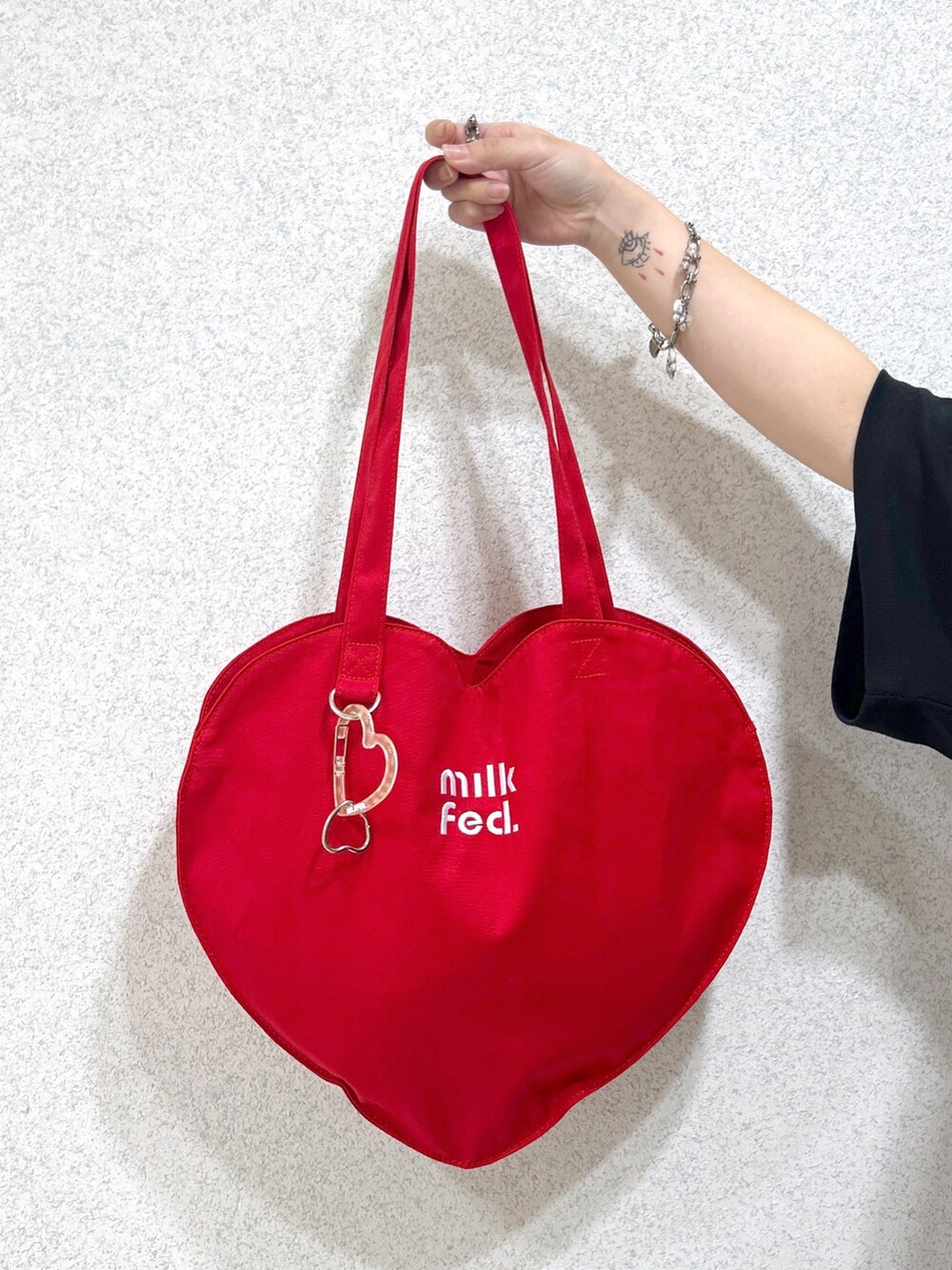 ブルー系のスカート、ブラック系のTシャツ/カットソー、レッド系のトートバッグを着用したレディースの夏コーディネートの9枚目の写真