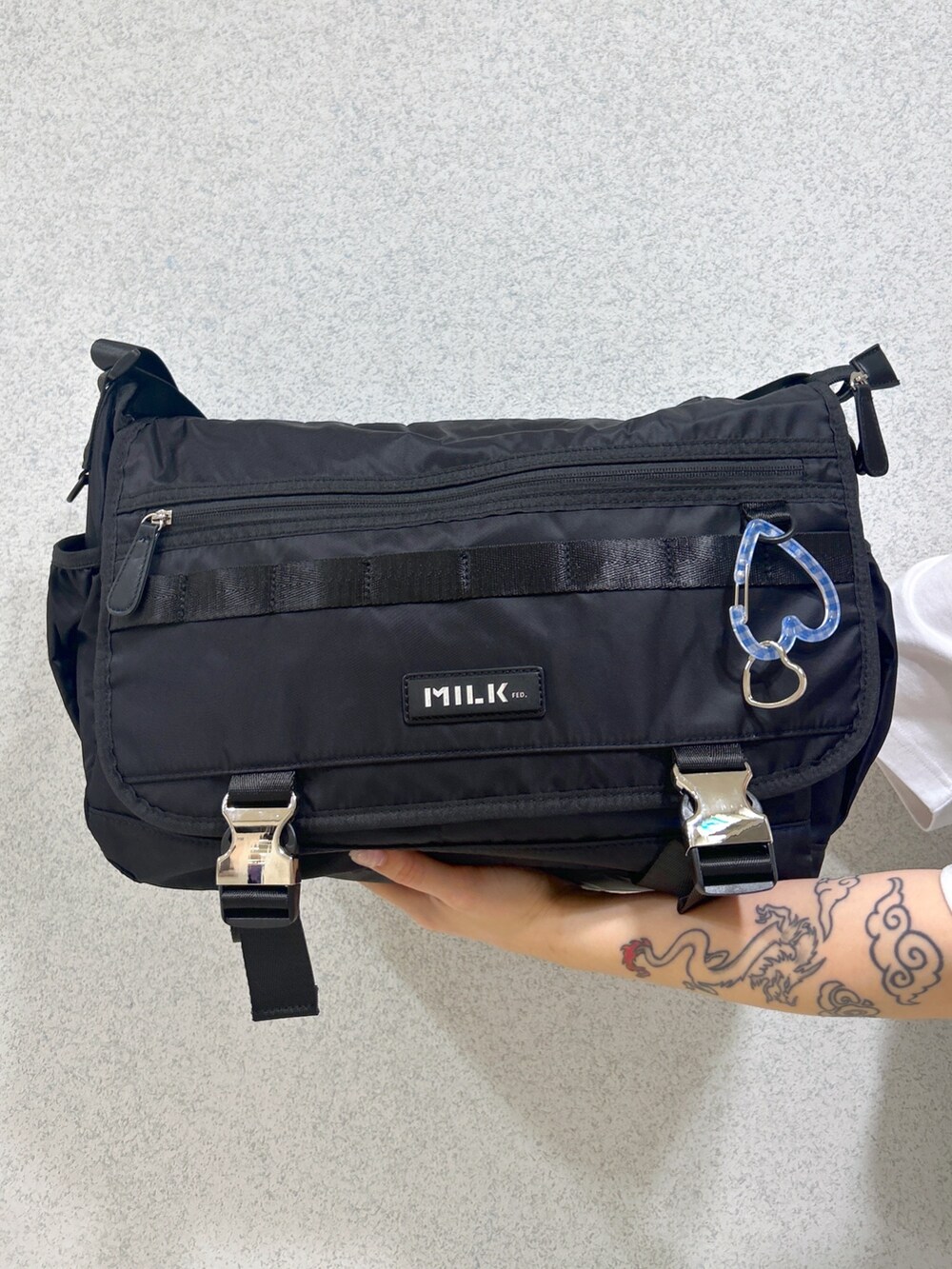 ホワイト系のTシャツ/カットソー、ブラック系のメッセンジャーバッグ、ブルー系のデニムスカートを着用したレディースの春コーディネートの7枚目の写真