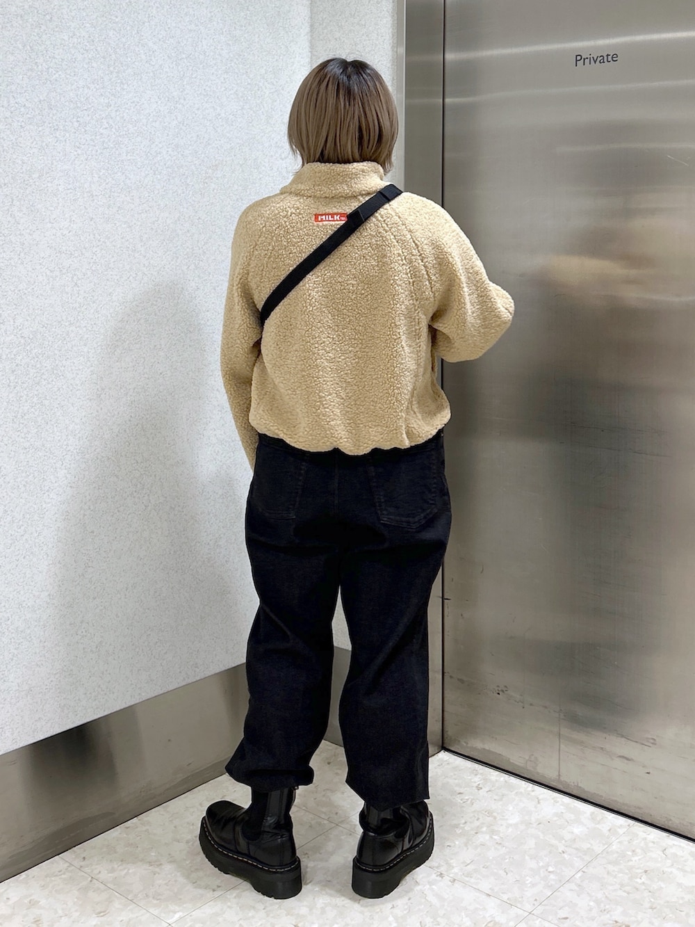 ピンク系のボディバッグ/ウエストポーチ、ピンク系のTシャツ/カットソー、ベージュ系のブルゾンを着用したレディースの冬コーディネートの4枚目の写真