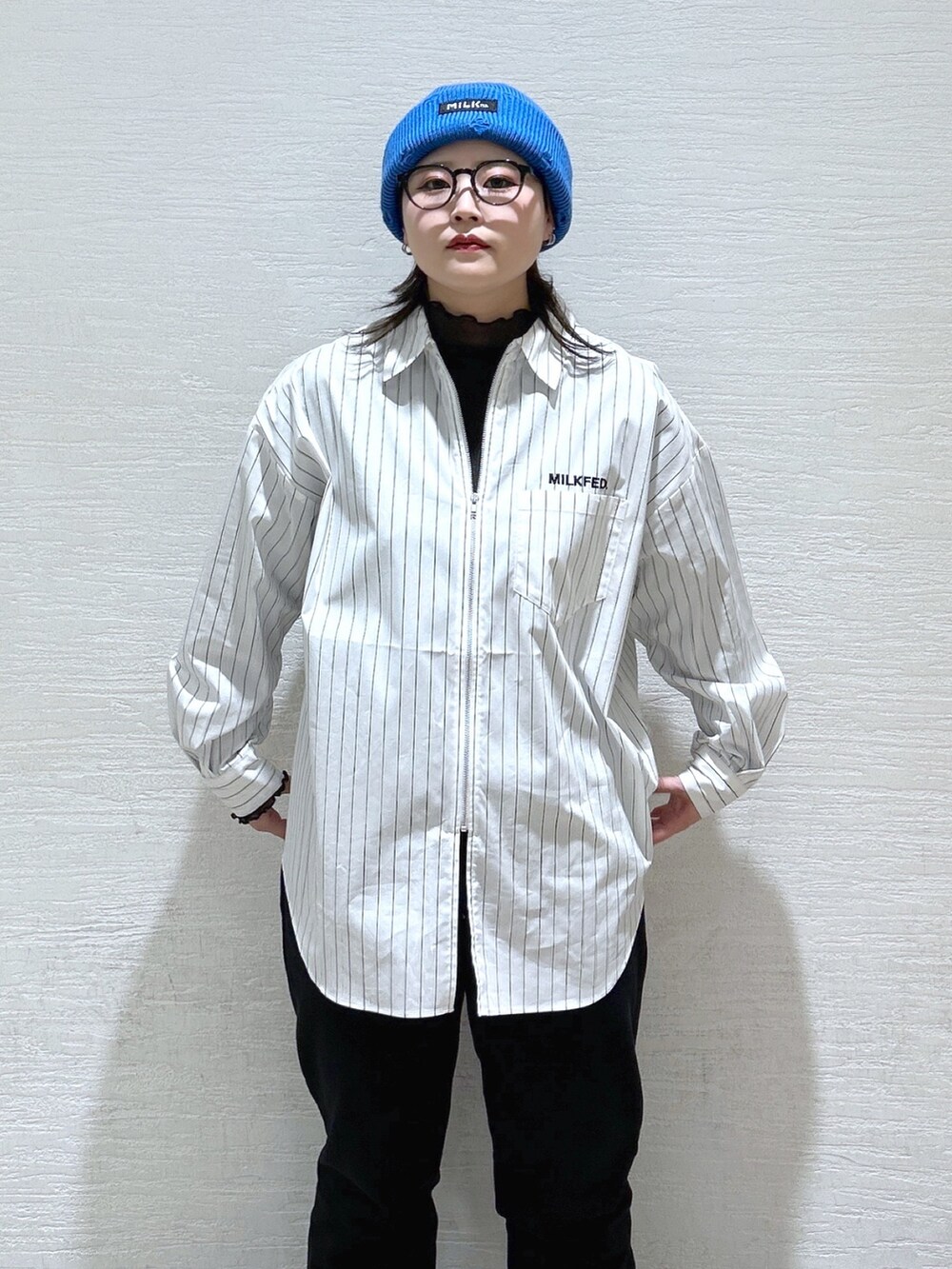 ホワイト系のシャツ/ブラウス、ブルー系のメッセンジャーバッグ、ブラック系のスウェットパンツを着用したレディースの冬コーディネートの7枚目の写真