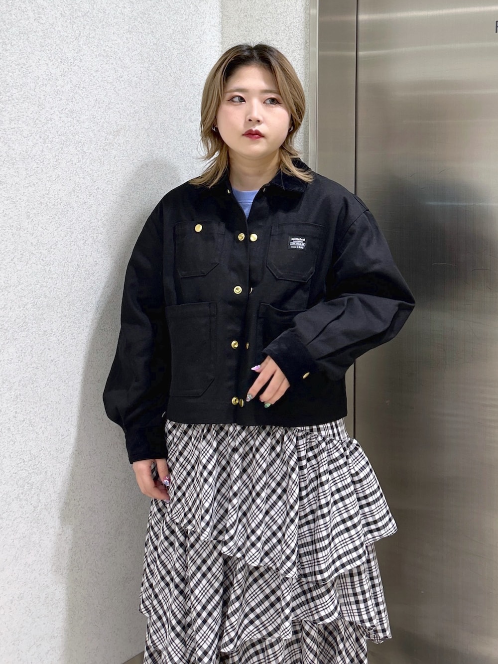 ブラック系のカバーオール、ブルー系のTシャツ/カットソー、ブラック系のスカートを着用したレディースの冬コーディネートの4枚目の写真