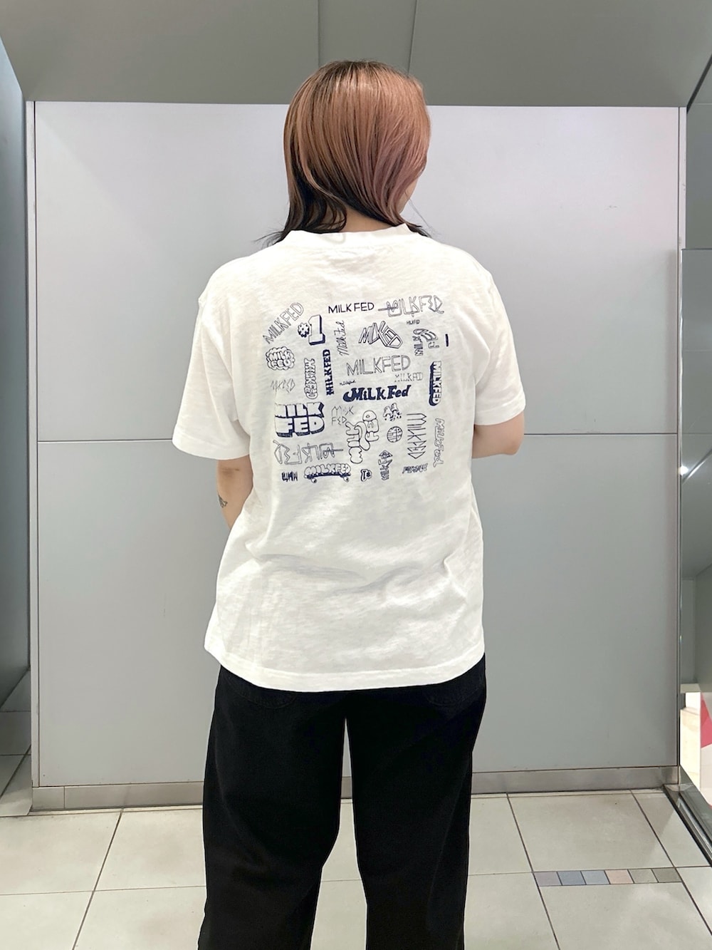 ブラック系のブーツ、ホワイト系のTシャツ/カットソー、ブラック系のデニムパンツを着用したレディースの夏コーディネートの5枚目の写真