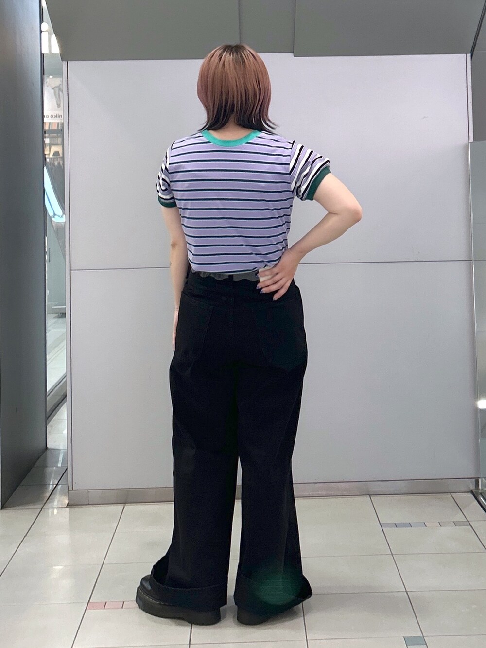 パープル系のTシャツ/カットソー、ブラック系のデニムパンツ、ブラック系のブーツを着用したレディースの夏コーディネートの4枚目の写真