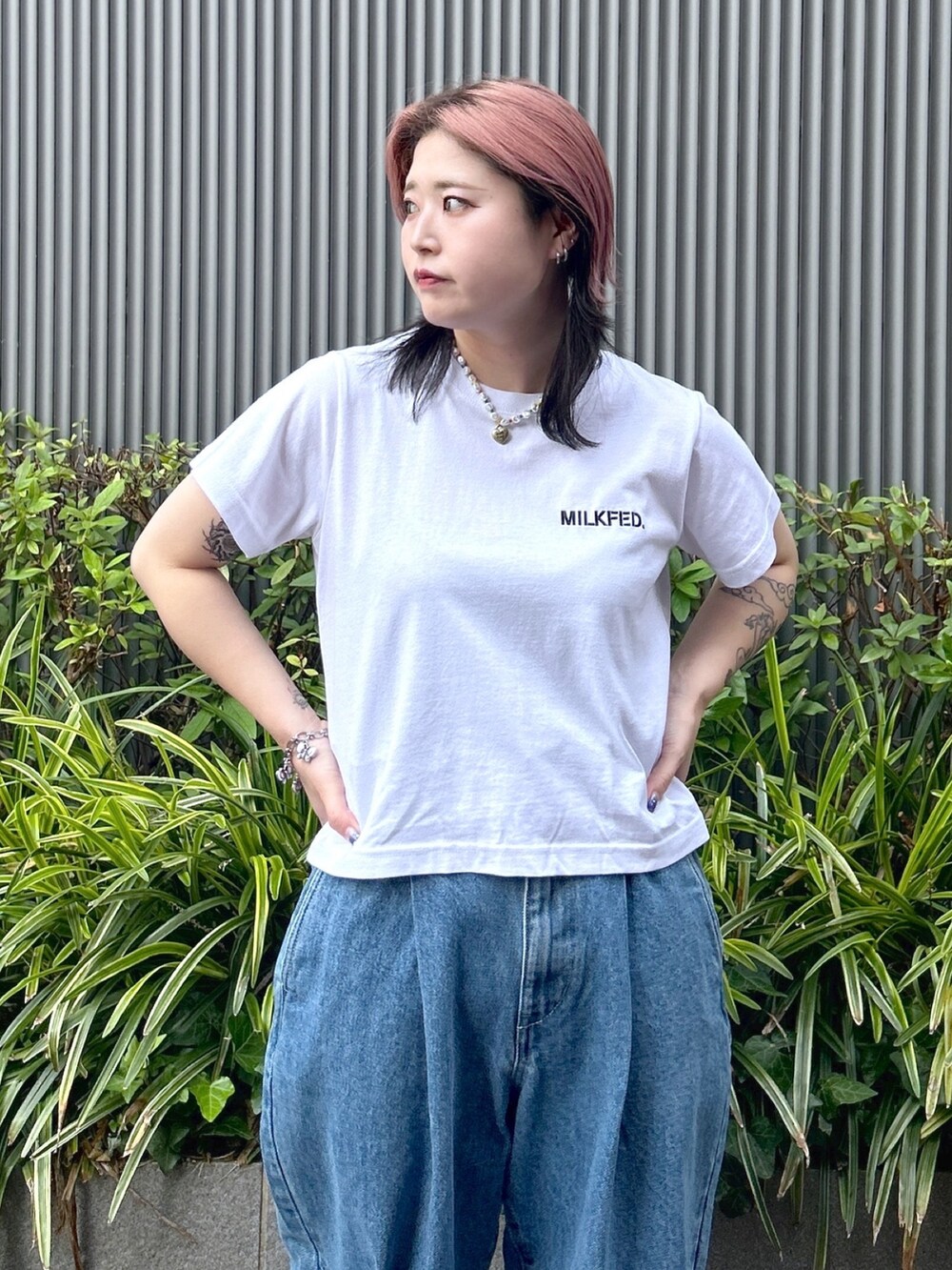 ブルー系のデニムパンツ、ホワイト系のTシャツ/カットソー、ベージュ系のサンダルを着用したレディースの夏コーディネートの5枚目の写真