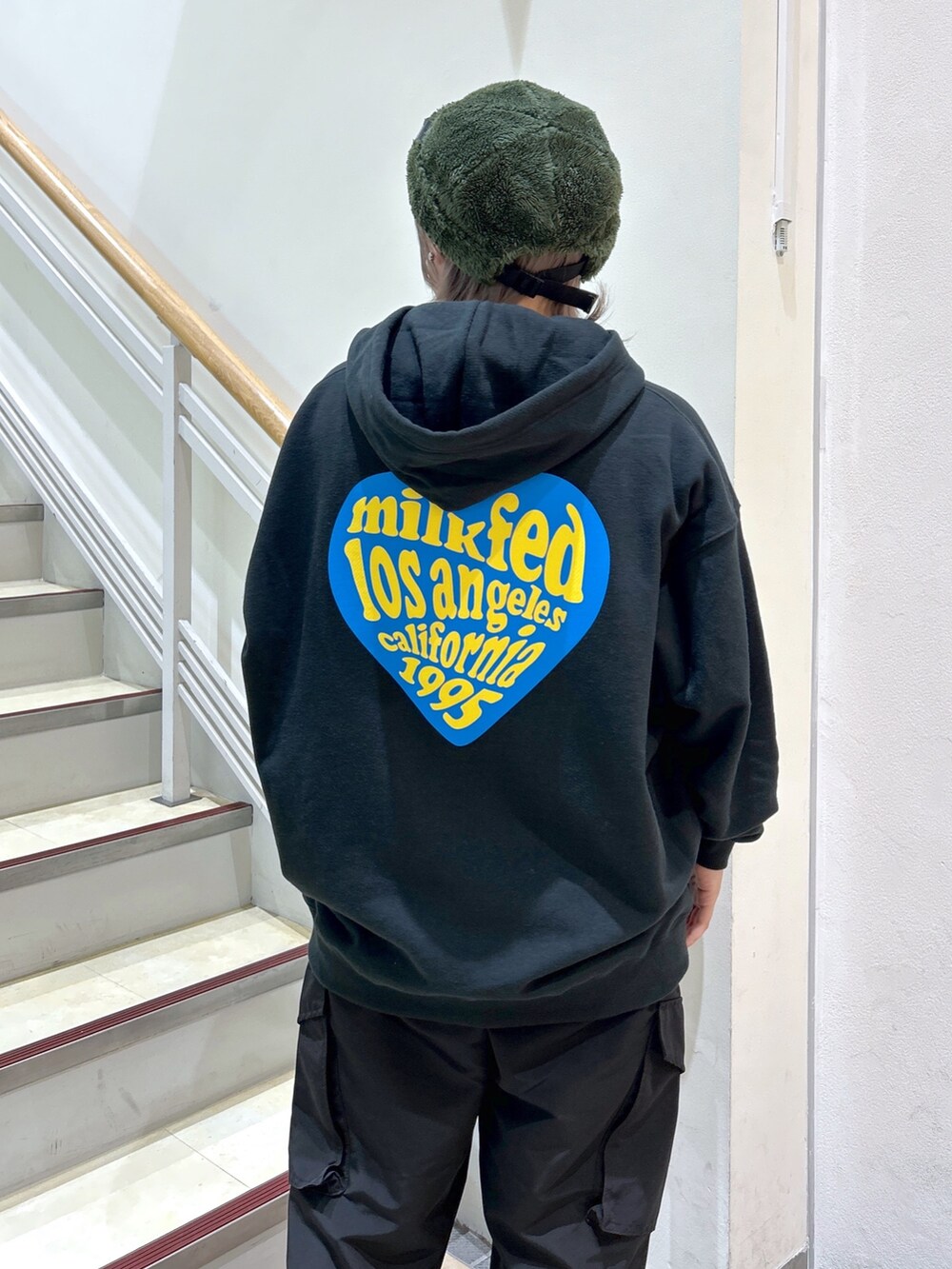 ブラック系のパーカー、ブラック系のショルダーバッグ、ブラック系のカーゴパンツを着用したレディースの秋コーディネートの4枚目の写真
