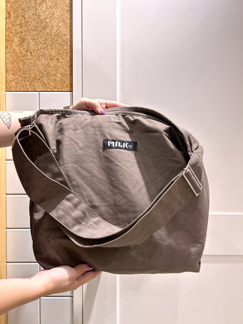 ブラック系のTシャツ/カットソー、ブラウン系のショルダーバッグ、レッド系のスカートを着用したレディースの秋コーディネートの5枚目の写真