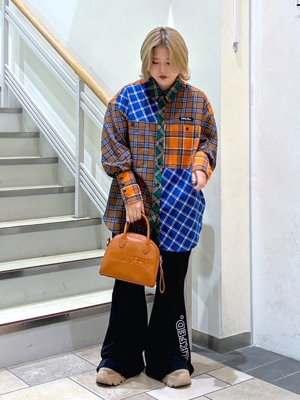 ブラウン系のシャツ/ブラウス、ブラウン系のボストンバッグ、ブラック系のスウェットパンツを着用したレディースの秋コーディネートの2枚目の写真